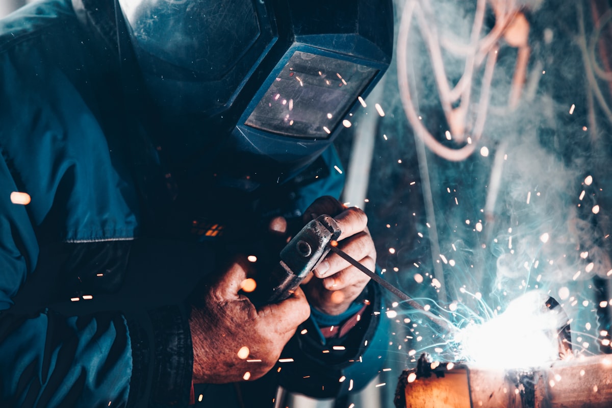 Soudeur au travail en atelier industriel, lumière dorée